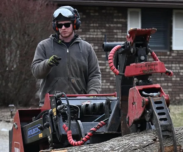 Joel Thompson of Kingdom Tree Company operating equipment during a tree removal in North Canton, Ohio